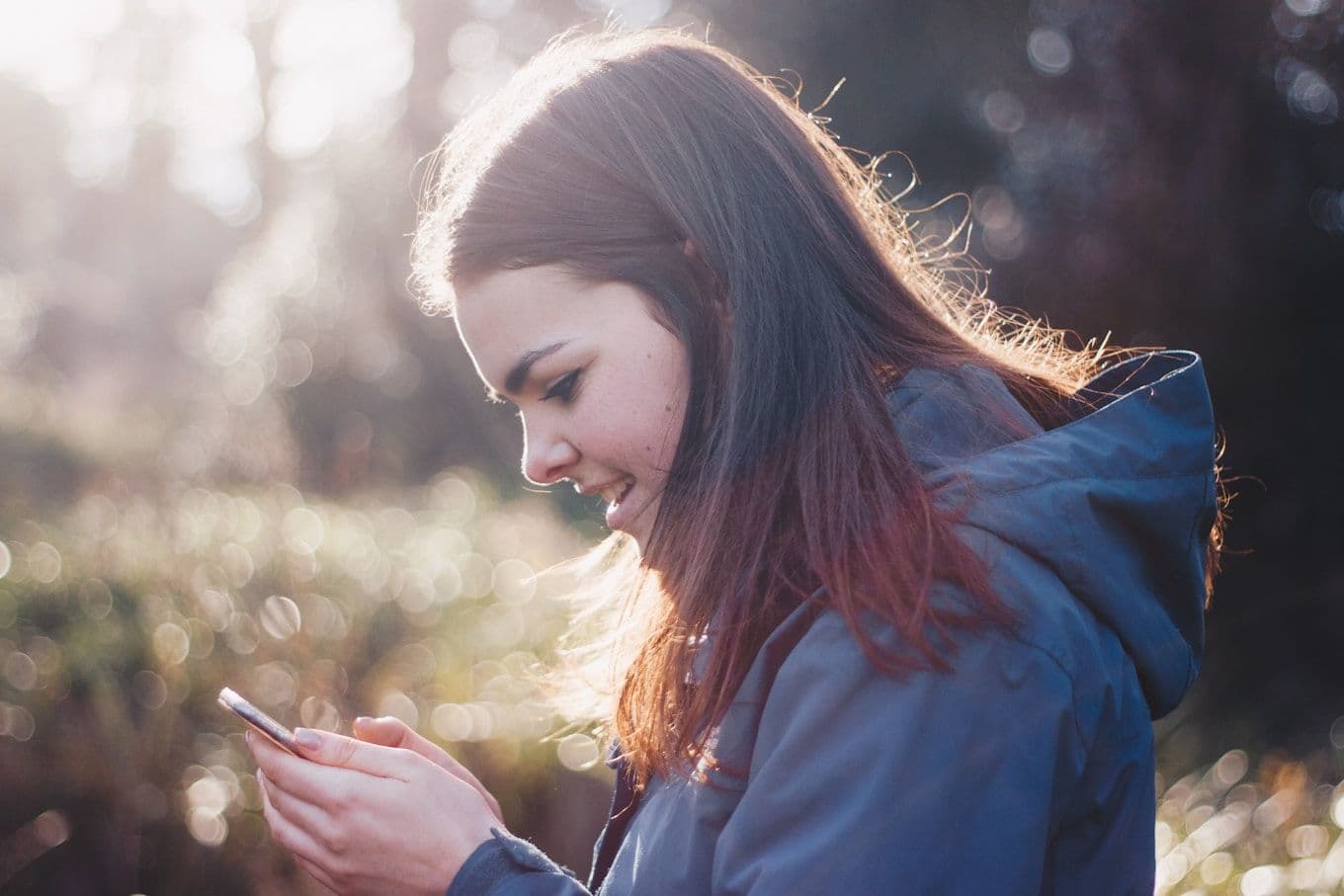 Gast bekijkt haar telefoon buiten tijdens een kampeervakantie